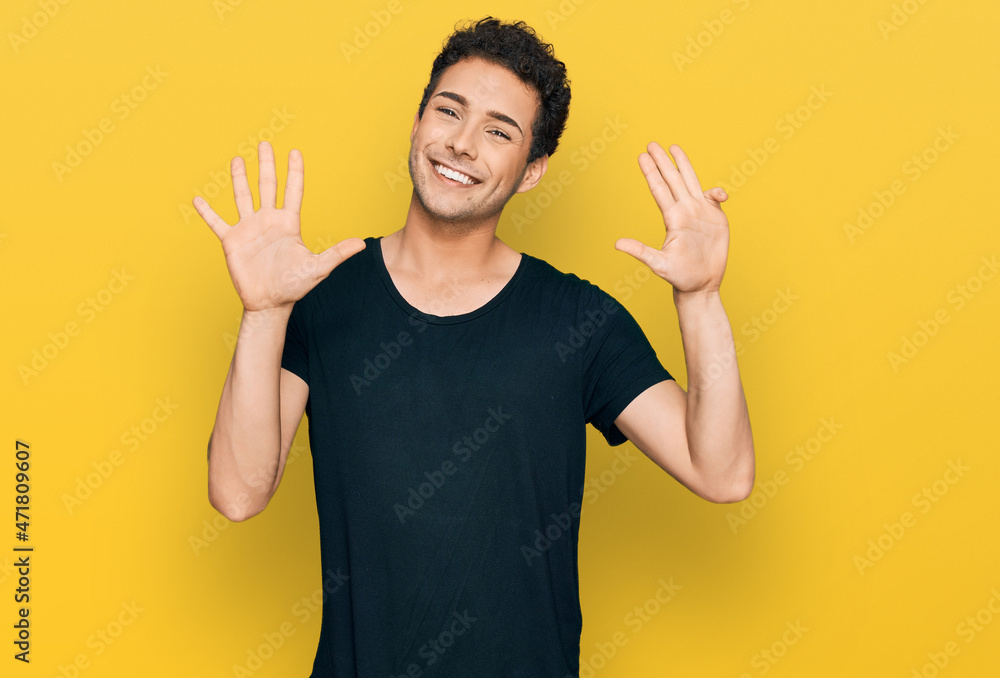 Young handsome man wearing casual black t shirt showing and pointing up with fingers number nine while smiling confident and happy. Young handsome man wearing casual black t shirt showing and pointing up with fingers number nine while smiling confident and happy.