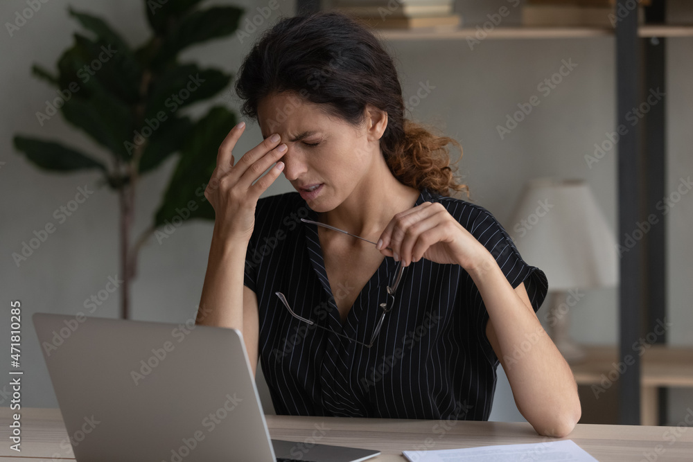 Sudden eye pain. Tired overworked latin woman office employee wince rub