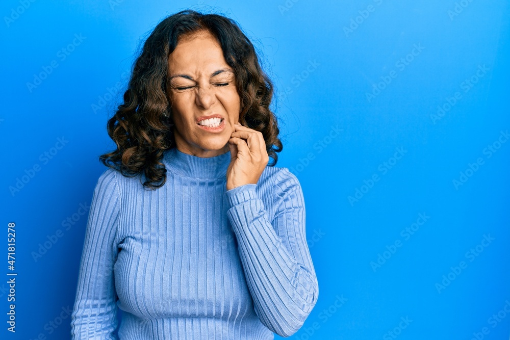 Fototapeta premium Middle age hispanic woman wearing casual clothes touching mouth with hand with painful expression because of toothache or dental illness on teeth. dentist