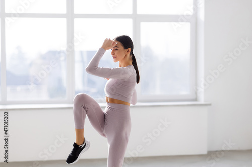 Sporty girl jumping on white background. Dynamic movement. Full length. Sports and healthy lifestyle