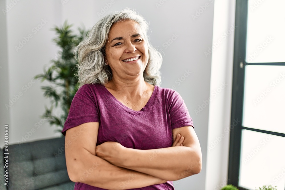 Middle age grey-haired woman smiling happy standing with arms crossed gesture at home. Middle age grey-haired woman smiling happy standing with arms crossed gesture at home.
