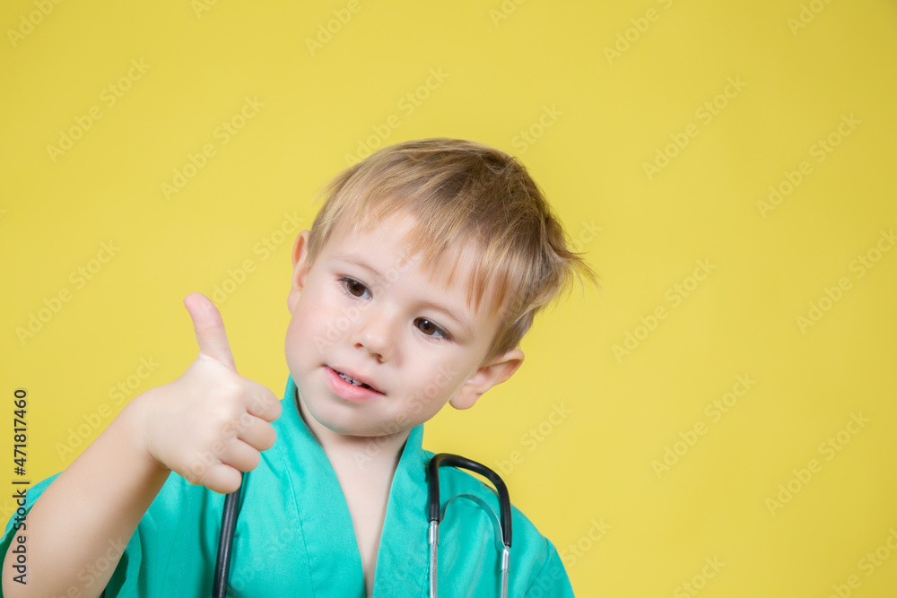 Portrait of little caucasian boy dressed in doctors showing thumb up gesture Portrait of little caucasian boy dressed in doctors showing thumb up gesture