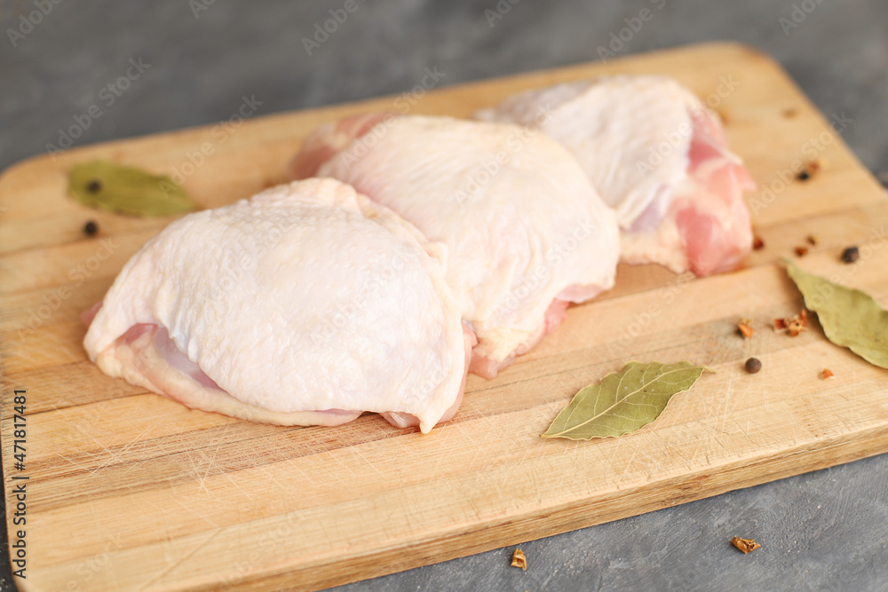 Fresh raw chicken thighs on wooden board