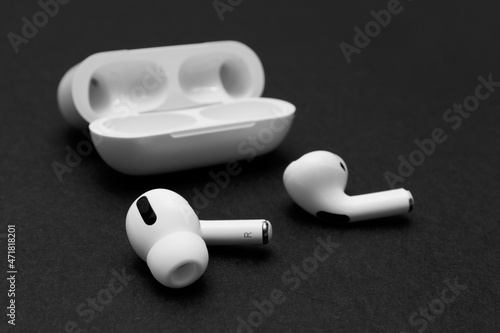 White wireless headphones with microphone and with Wireless Charging Case on black background