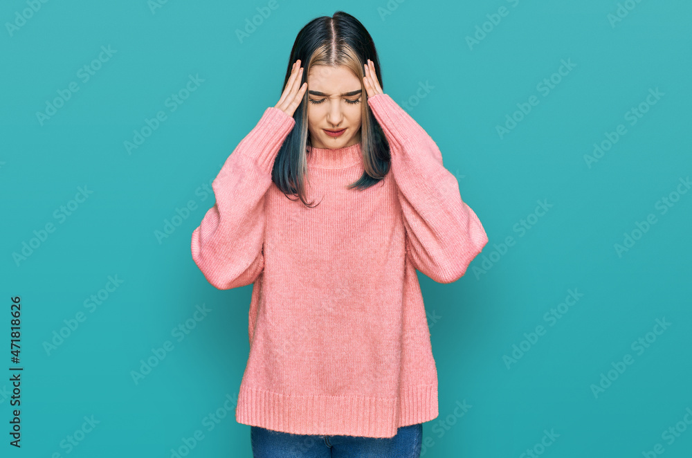 Young modern girl wearing pink wool winter sweater with hand on head for pain in head because stress. suffering migraine. Young modern girl wearing pink wool winter sweater with hand on head for pain in head because stress. suffering migraine.