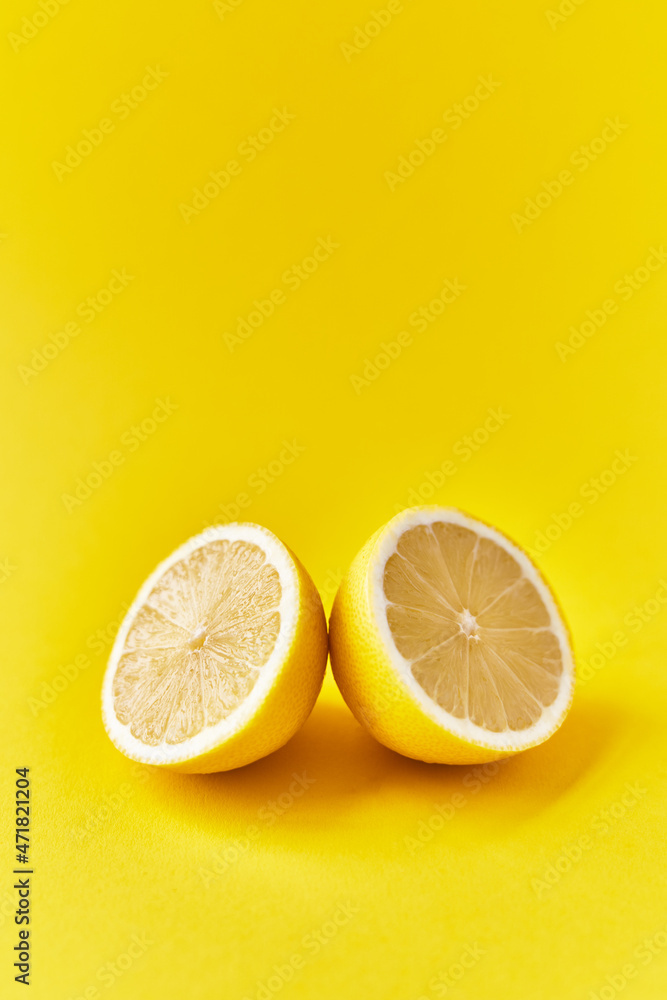 Two lemon halves fruit on a yellow background Two lemon halves fruit on a yellow background