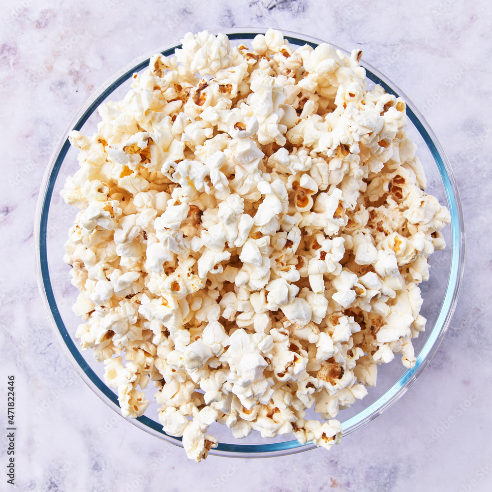 Bowl of salty popcorns on a marble surface Bowl of salty popcorns on a marble surface