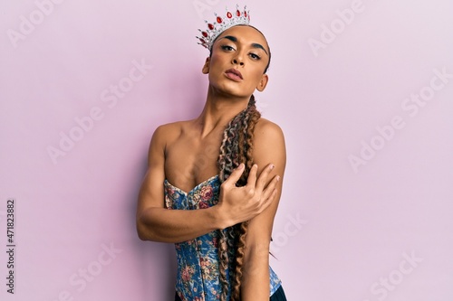 Sensual hispanic transgender woman wearing queen crown and posing glamorous with seductive face wearing sexy lingerie photo