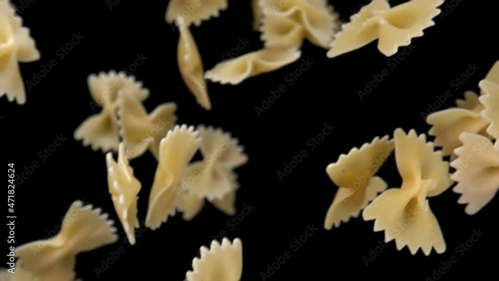 Close-up of the pasta Farfalle falling down on a black background Close-up of the pasta Farfalle falling down on a black background