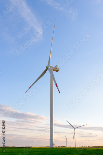 View on alternative energy windmills in a windpark in Ulyanovsk in front of a blue sky. Windmills for electric power production.