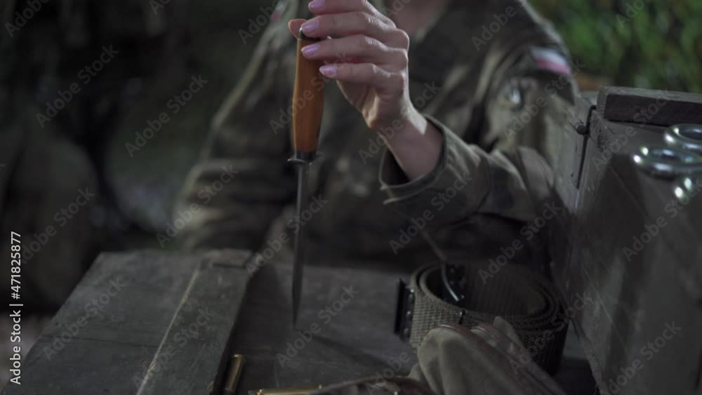 A soldier sticks a bayonet in the lid of a box and spins it around. Difficult choices in the military. A soldier sticks a bayonet in the lid of a box and spins it around. Difficult choices in the military.