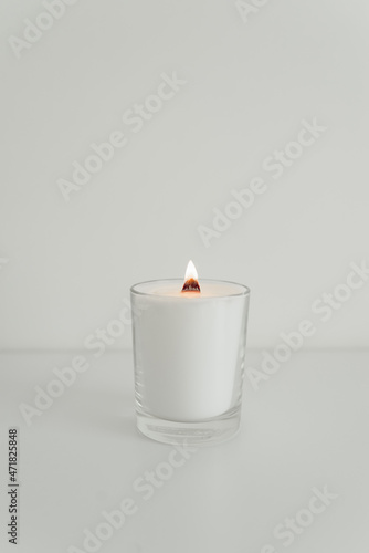 Burning white candle with a wooden wick