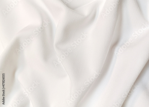 White crumpled or wavy fabric texture background. Abstract linen cloth soft waves. Creases of satin, silk, and cotton. Smooth elegant silk or atlas luxury cloth texture. Bedding Sheets or blanket.