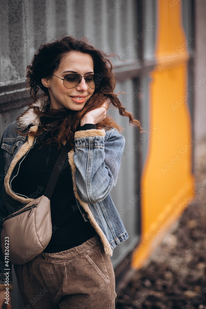 Obraz premium Young woman with curly hair in denim jacket