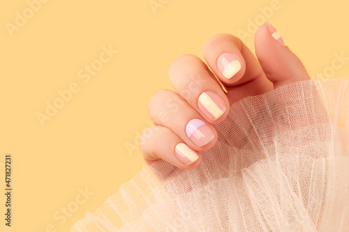 Foto Beautiful females hand with manicure on yellow background