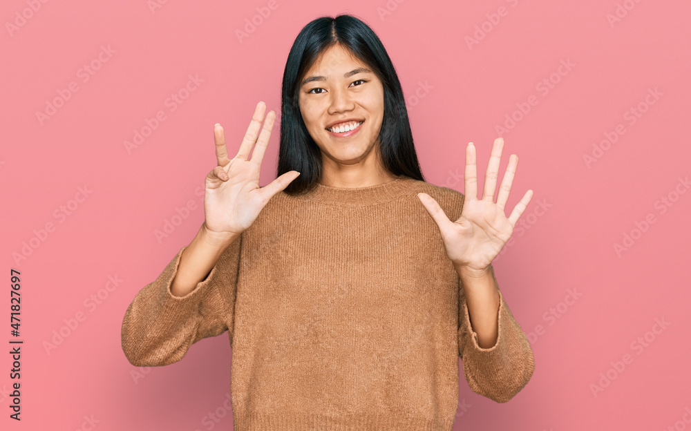Beautiful young asian woman wearing casual winter sweater showing and pointing up with fingers number nine while smiling confident and happy. Beautiful young asian woman wearing casual winter sweater showing and pointing up with fingers number nine while smiling confident and happy.