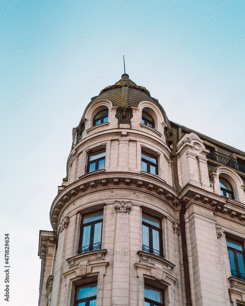 Old building from Bucharest with beautiful architecture and balcony, vibrant sky
