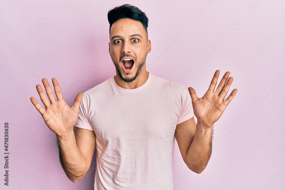 Fototapeta premium Young arab man wearing casual clothes celebrating crazy and amazed for success with arms raised and open eyes screaming excited. winner concept