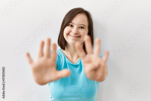 Wallpaper Mural Young down syndrome woman standing over isolated background showing and pointing up with fingers number nine while smiling confident and happy. Torontodigital.ca
