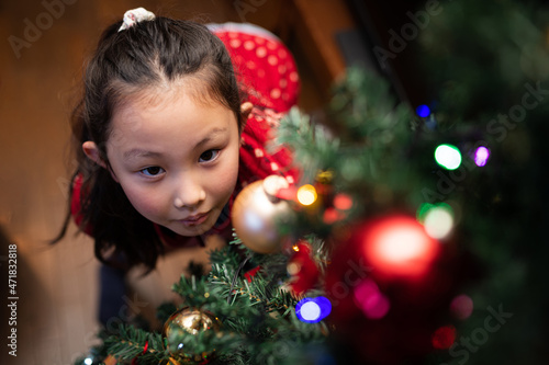 クリスマスツリーの飾りつけをする少女