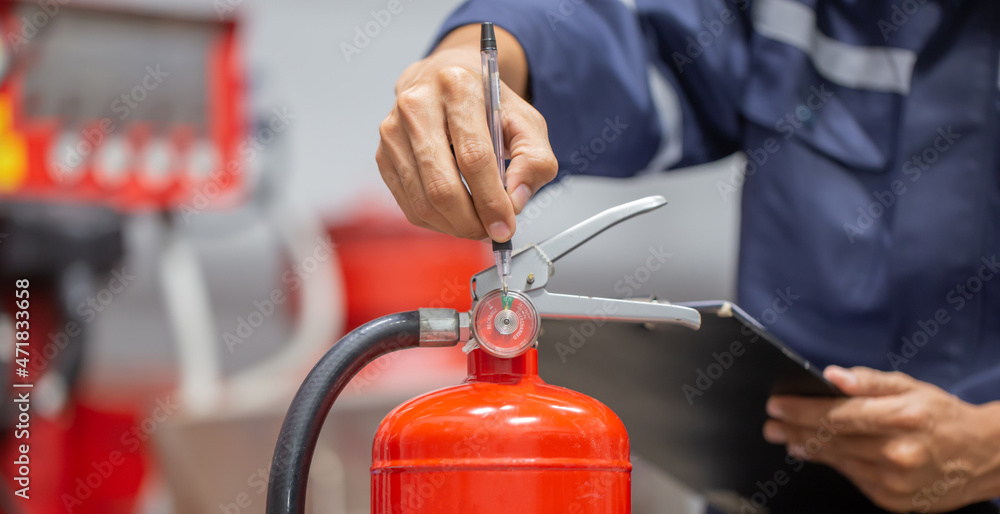 Engineer are checking and inspection a fire extinguishers tank in the fire control room for safety training and fire prevention. Engineer are checking and inspection a fire extinguishers tank in the fire control room for safety training and fire prevention.
