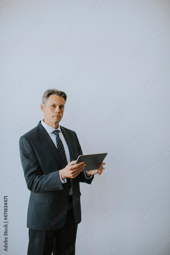Business man using digital tablet by the wall in the office Business man using digital tablet by the wall in the office