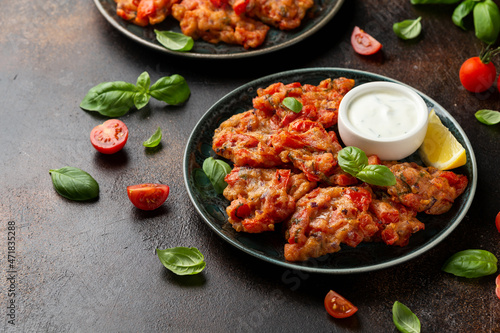 Greek tomato fritters, tomatokeftedes served with yogurt on plate.