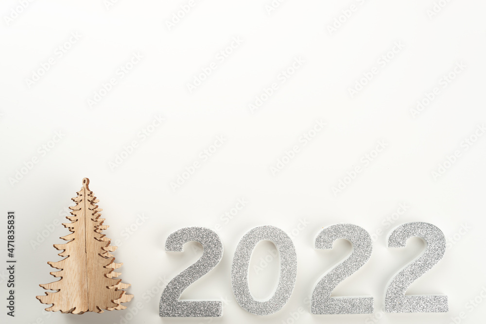Little wooden Christmas tree with 2022 numbers on light background. Copy space.