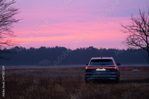 Close-up of a car on a purple background of sunset and forest, copy space