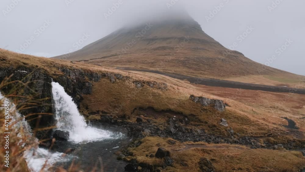 Base of Kirkjufellsfoss Waterfall, mist-covered Kirkjufell in background. Iceland. Slow motion. Base of Kirkjufellsfoss Waterfall, mist-covered Kirkjufell in background. Iceland. Slow motion.