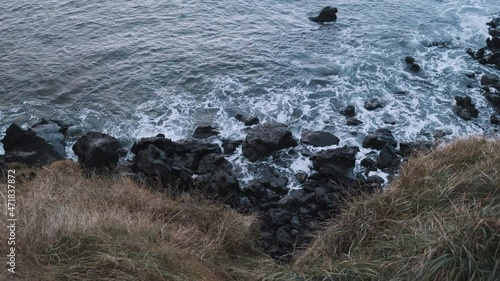 Top down view looking over cliff of Hellisandur, Iceland, ocean surf on rocks. photo