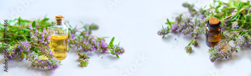 Thyme essential oil in a small bottle. Selective focus.