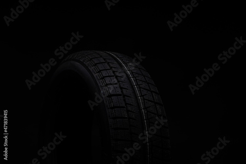 photograph of a black tire on a dark background
