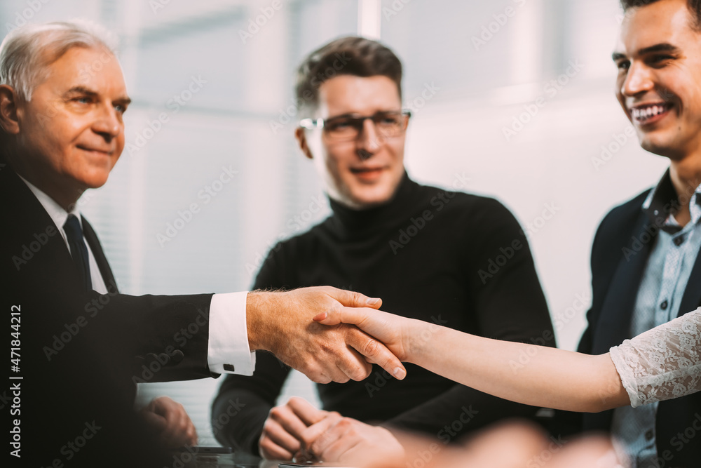 serious businessman shaking hands with a young business man