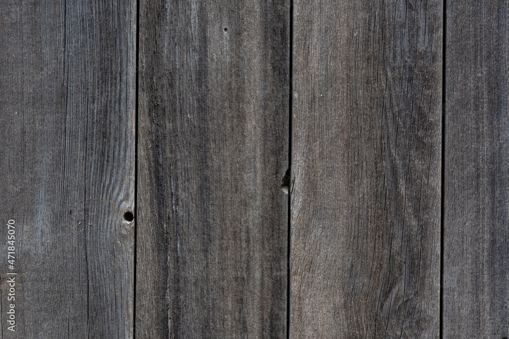 The background is made of beautiful wooden boards on the textured wall of an economic structure. The texture of the walls of an old building, in a distant village, in Russia. The background is made of beautiful wooden boards on the textured wall of an economic structure. The texture of the walls of an old building, in a distant village, in Russia.