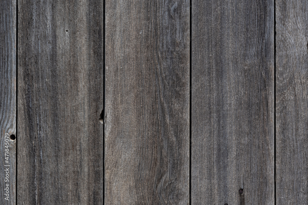 The background is made of textured old wooden boards. Old wooden boards, grayed with time, with a beautiful wood texture. The background is made of textured old wooden boards. Old wooden boards, grayed with time, with a beautiful wood texture.