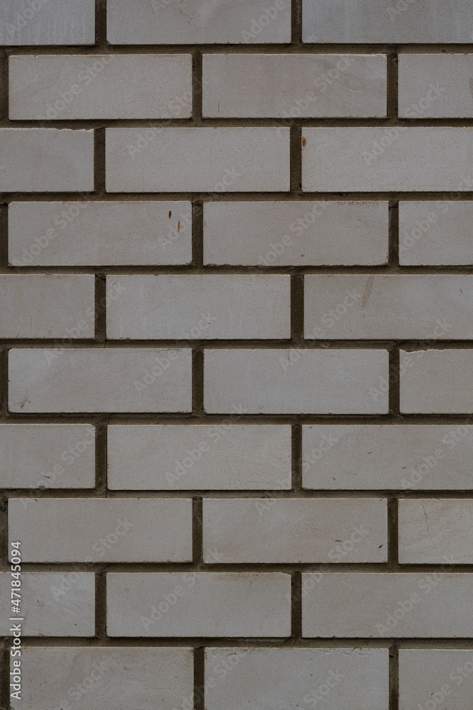 Vertical photo of the background of a white brick wall. The texture of a brick wall made of white silicate brick. Vertical photo of the background of a white brick wall. The texture of a brick wall made of white silicate brick.