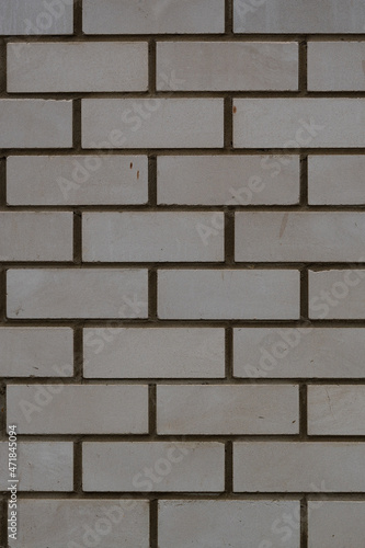 Vertical photo of the background of a white brick wall. The texture of a brick wall made of white silicate brick.