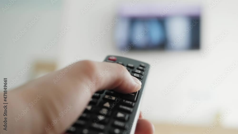 Close-up of switching channels tv. Person watching smart TV and uses remote control. Close-up of switching channels tv. Person watching smart TV and uses remote control.