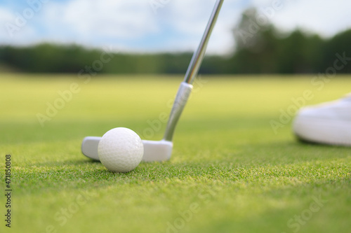 Golf approach shot with iron from fairway at sunny day.