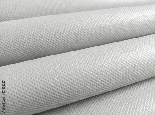 rolled white polypropylene fabric. non-woven fabric background with fibrous texture. industrial bag material photo