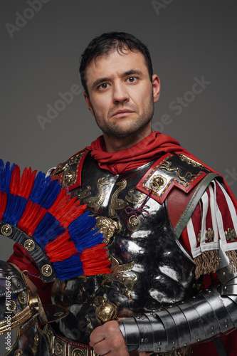Powerful roman centurion with plumed helmet isolated on gray