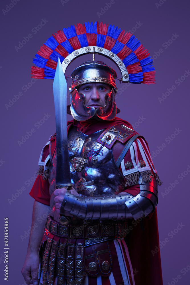 Shot of ancient roman soldier posing in colorful dark light Shot of ancient roman soldier posing in colorful dark light
