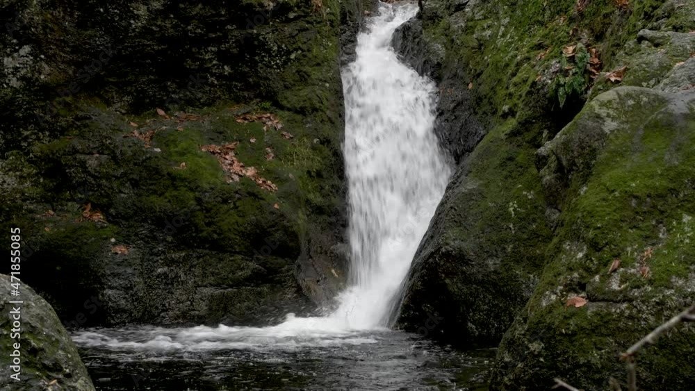 waterfall flowing into a pool below on a wet cloudy fall day in a New England state park located in Shelton CT
