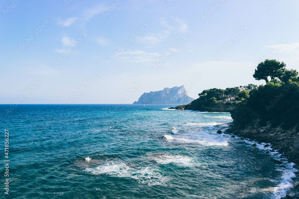 View of mediterranean sea with blue waters and waves in contrast with green nature