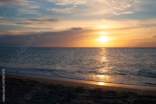 Colorful sunset at the sandy beach looking at ocean