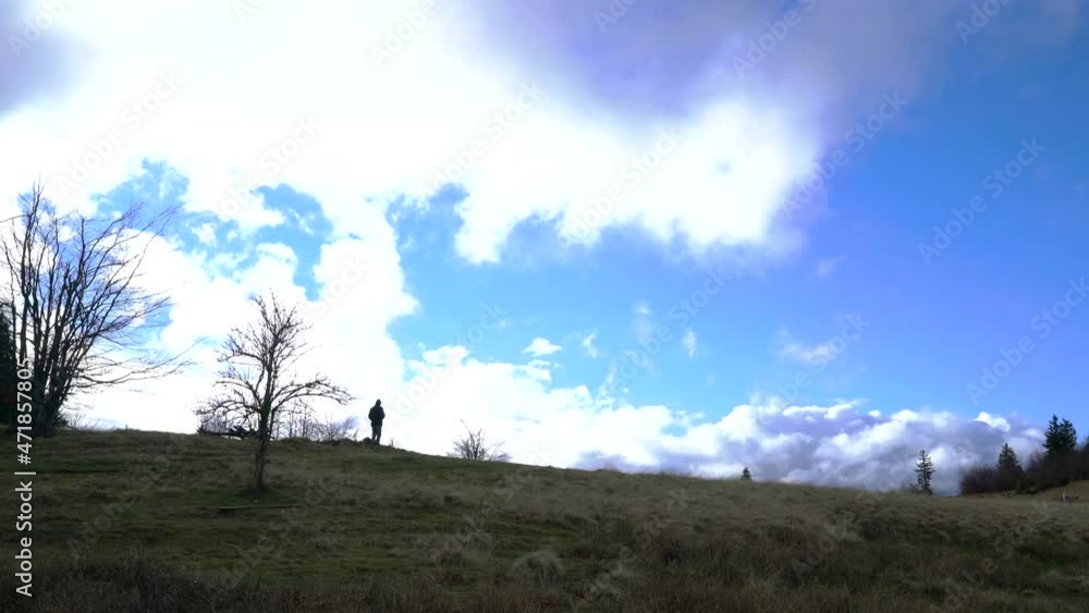 Mountaineer watching moving clouds into distance - (4K) Mountaineer watching moving clouds into distance - (4K)