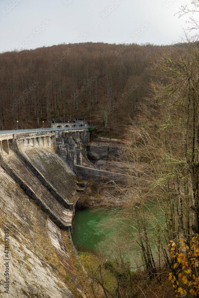 General view of the Irabia dam. Almost all of its gates are closed. The leafy trees of the Irati forest frame the image, ORBAITZETA,Navarra, Spain General view of the Irabia dam. Almost all of its gates are closed. The leafy trees of the Irati forest frame the image, ORBAITZETA,Navarra, Spain