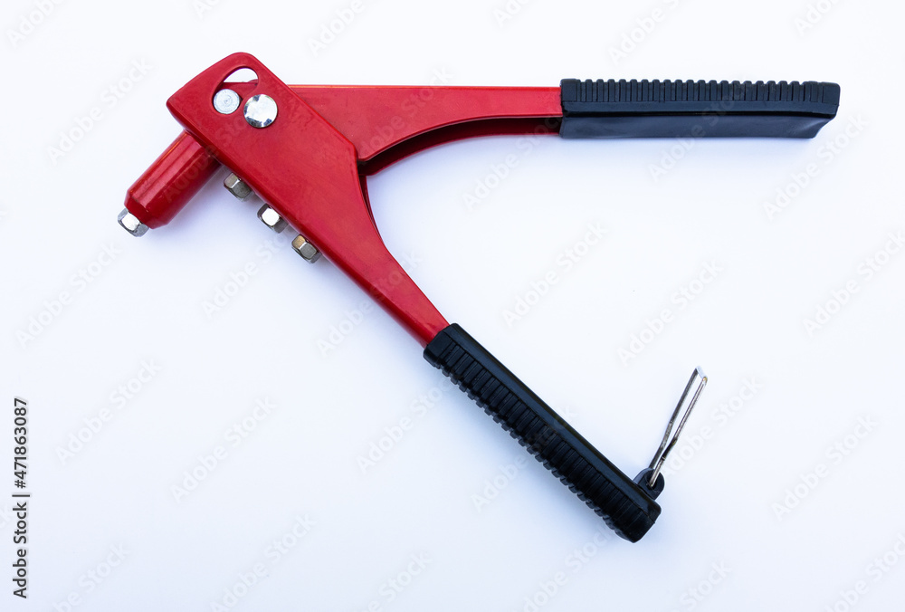 Red metal tool for tightening rivets on white isolate. The riveter is manual. The production tool is red. Red metal tool for tightening rivets on white isolate. The riveter is manual. The production tool is red.