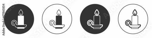Black Burning candle in candlestick icon isolated on white background. Cylindrical candle stick with burning flame. Circle button. Vector